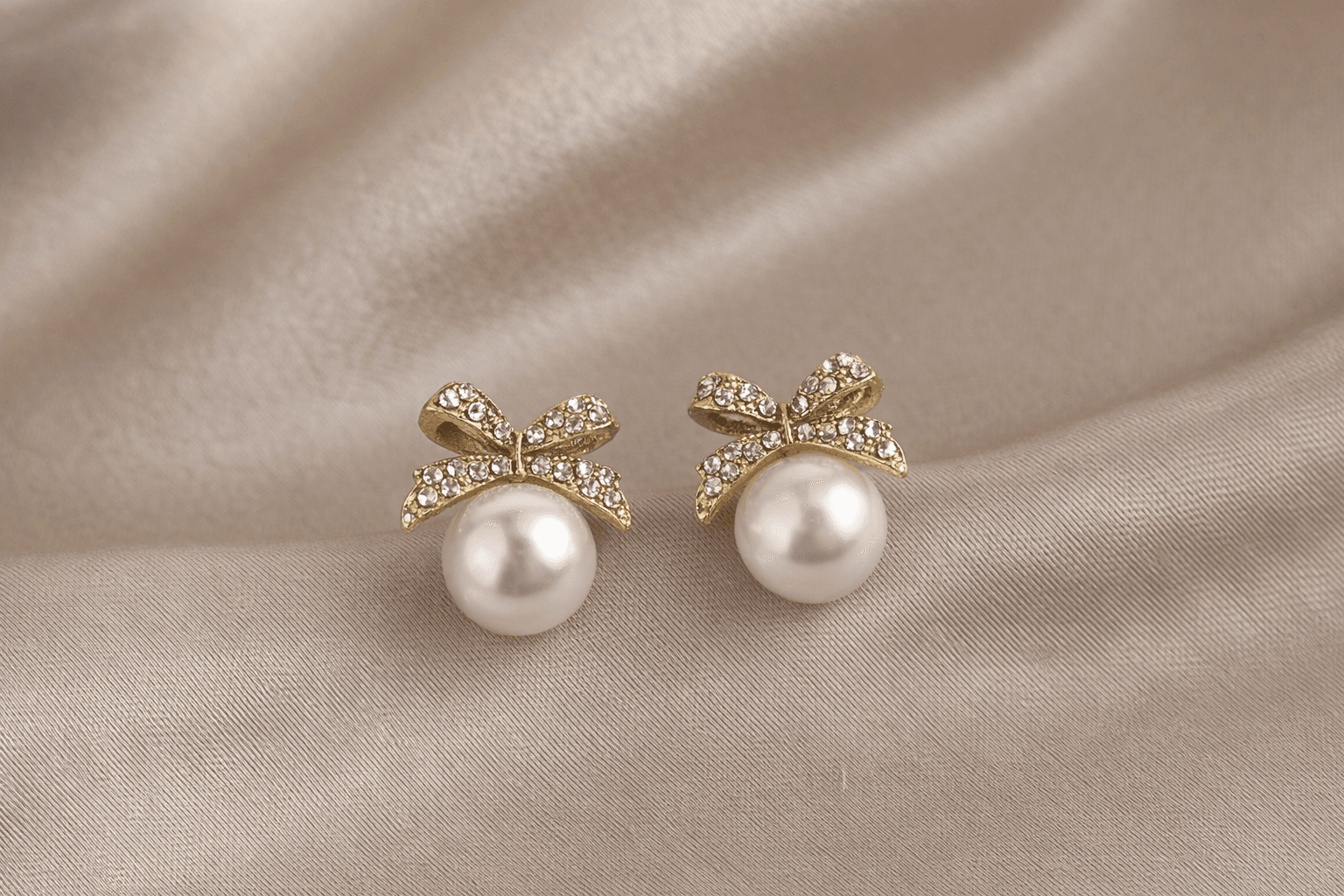 Gold Toned Bow Pearl Stud Earrings with American Diamonds